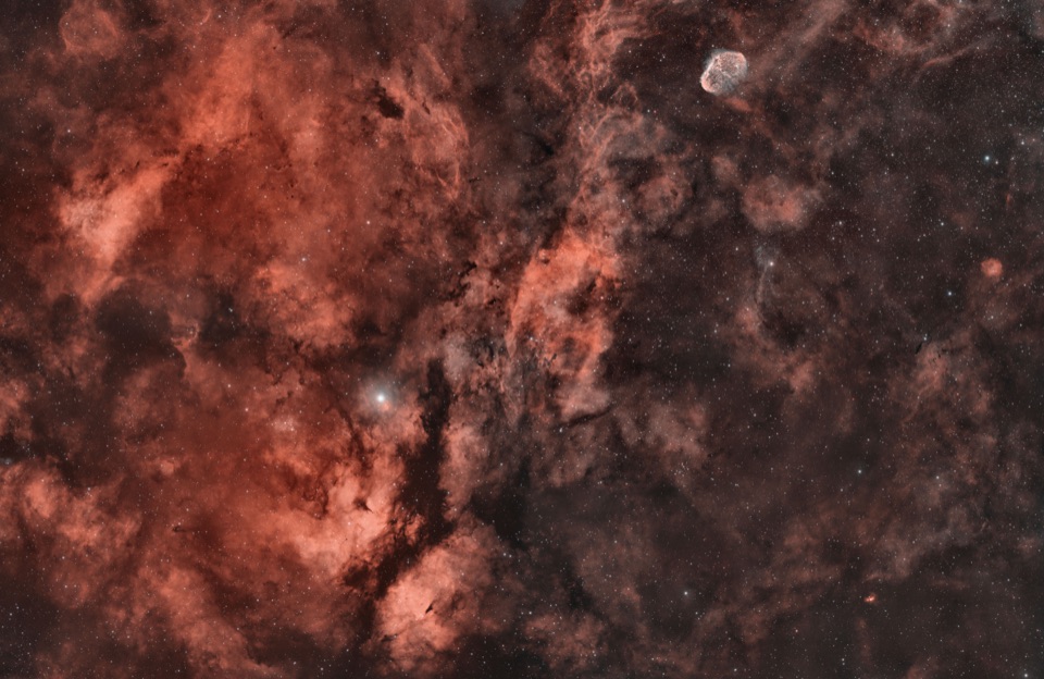 The Sadr Region, a four panel mosaic of hydrogen and oxygen gas around the star Sadr in Cygnus, with the Crescent Nebula near one corner
